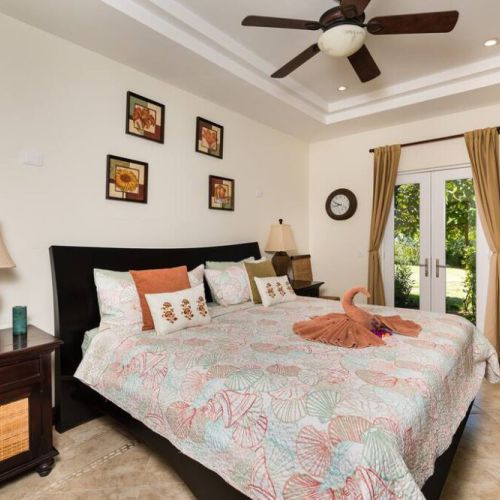 The master bedroom is furnished with a kingsized bed.